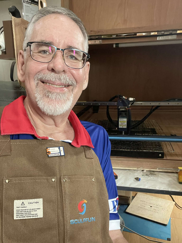 Andy Picton in his workshop, wearing an apron gifted by the Sculpfun team