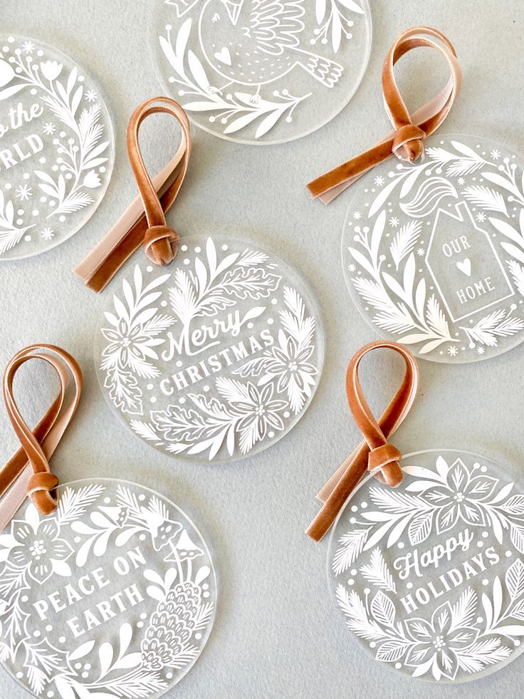 Personalized transparent acrylic Christmas decorations with laser engraved text and brown ribbons, made using a Sculpfun laser marker
